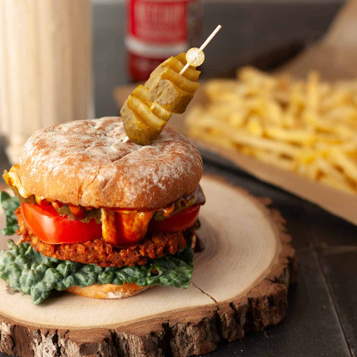 Baked vegan TVP and lentil burger on a bun with lettuce and tomato.