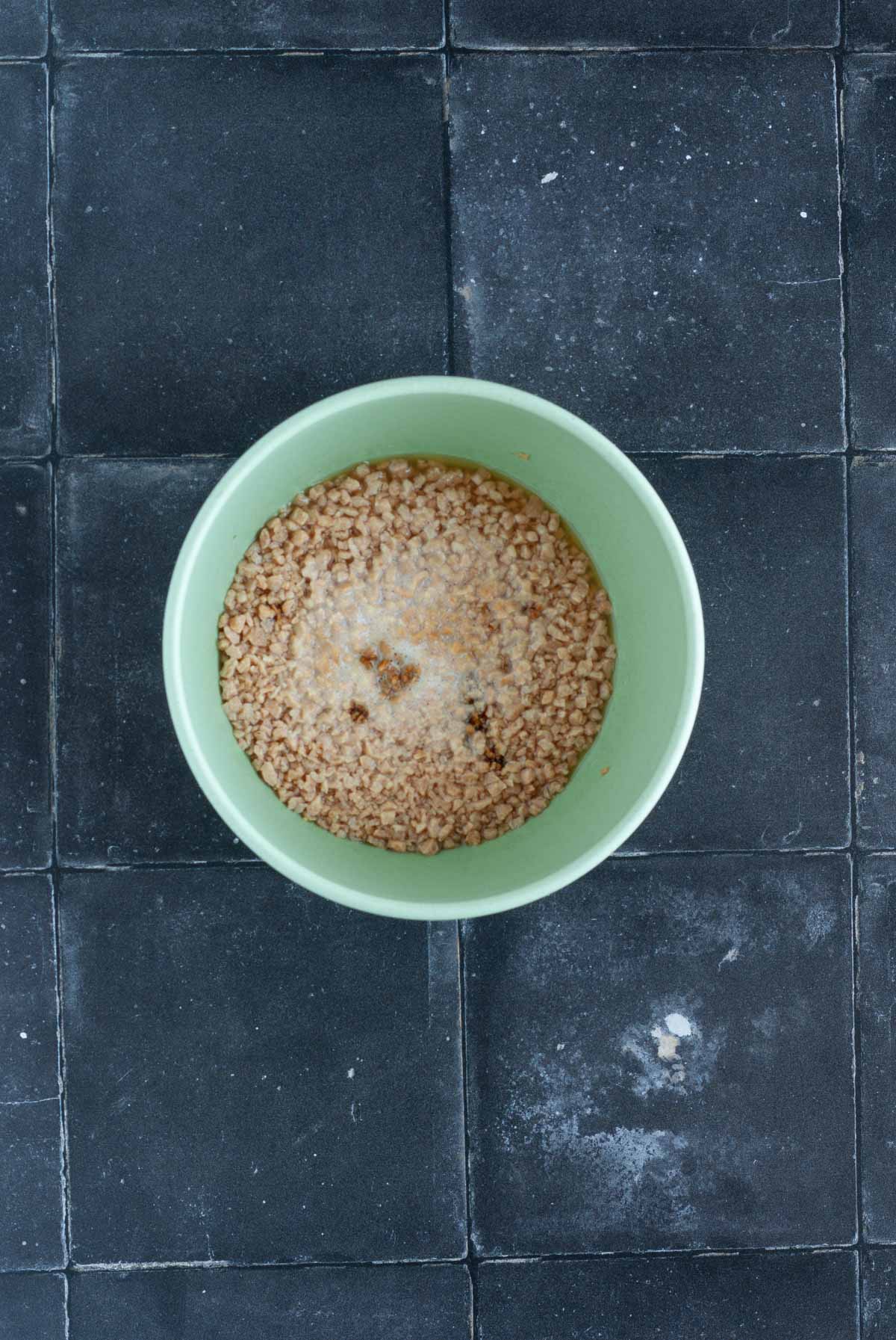 Textured Vegetable Protein and broth in a mixing bowl.