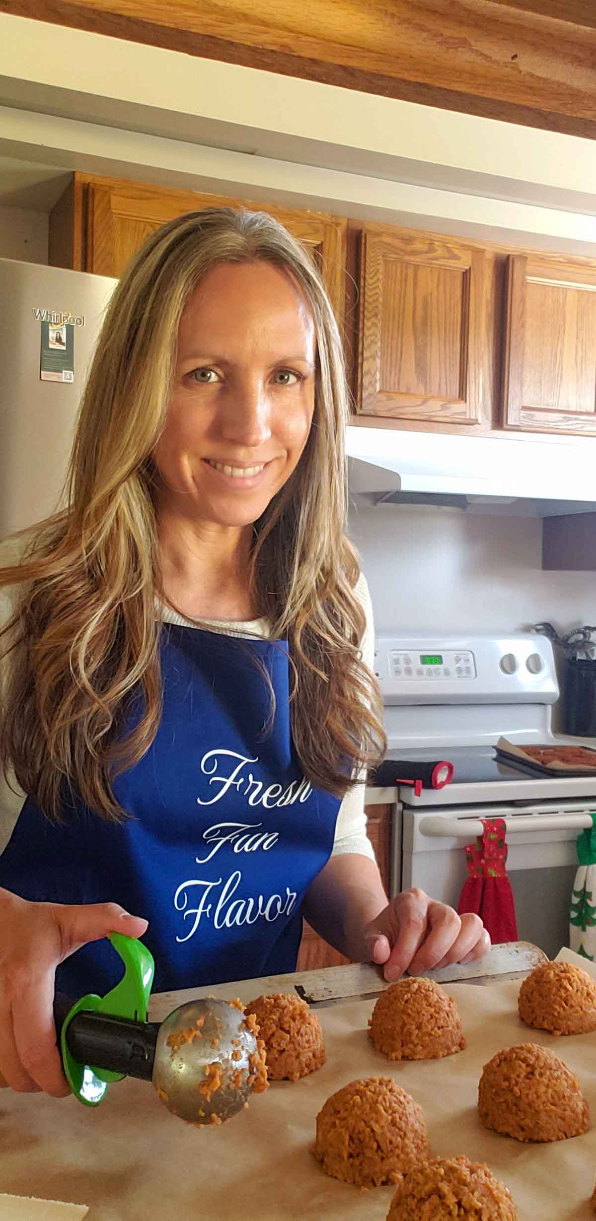 Rhonda in a blue apron scooping the burger mixture onto a baking sheet.