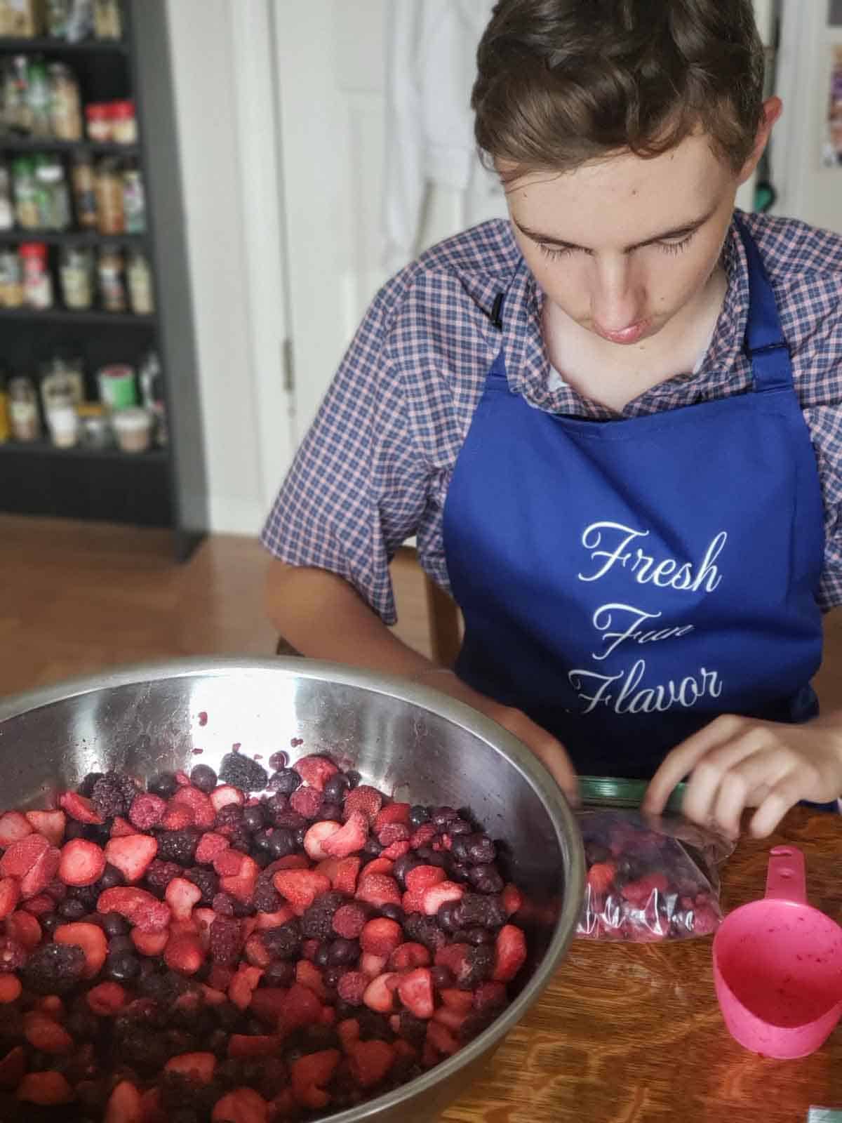 Justin sitting at a table portioning out berries into ziplock bags for the smoothie recipe.