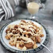 Vegan sausage and lentils with balsamic reduction on a plate of roasted cauliflower and drizzled with the lemon tahini sauce.