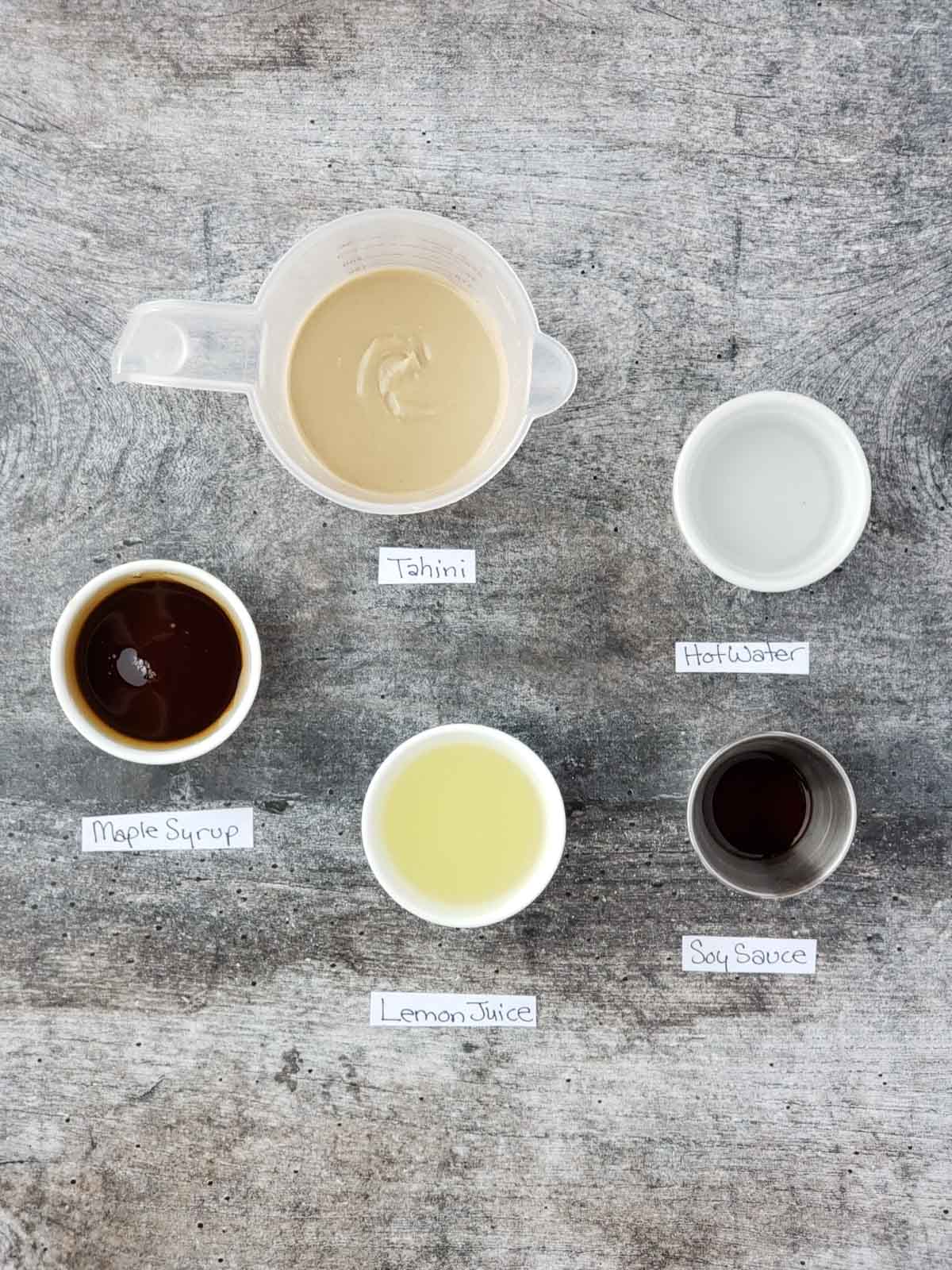 Ingredients for the lemon tahini sauce including maple syrup, tahini, lemon juice, and soy sauce.