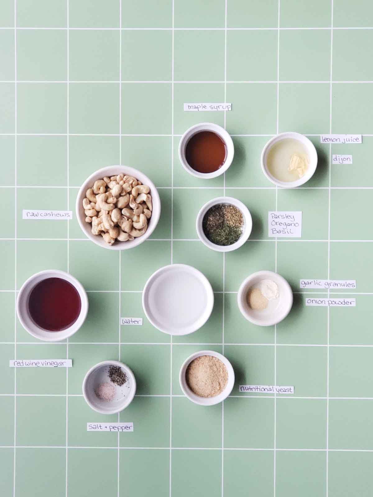 Ingredients for making creamy vegan italian dressing measured out into little white ramekins with handwritten labels next to each one.