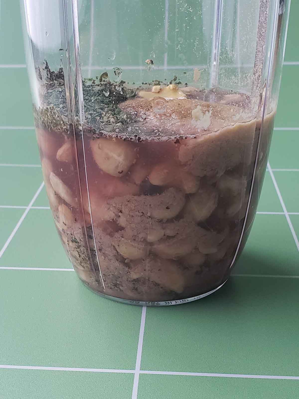 Ingredients in a blender cup ready to be blended into the creamy italian dressing.