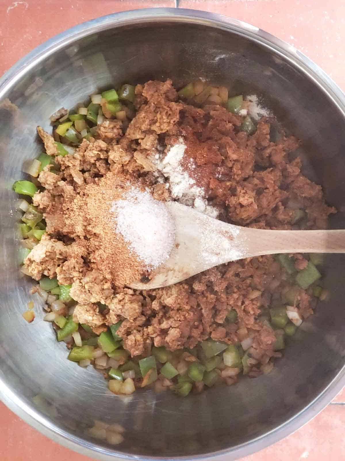 Spices sprinkled over ingredients in pot.