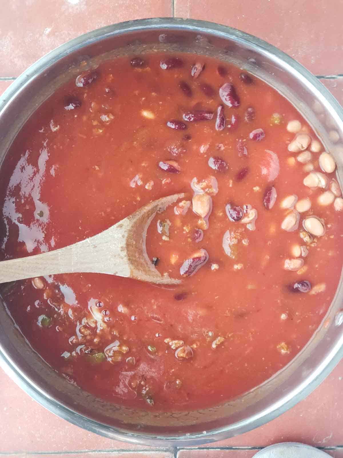 Uncooked vegan chili mixture with beans, tomatoes, and plant-based protein before long simmer.