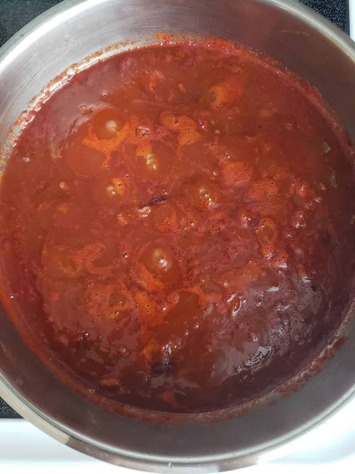 Vegan chili bubbling in pot during long simmer until thick and flavorful.