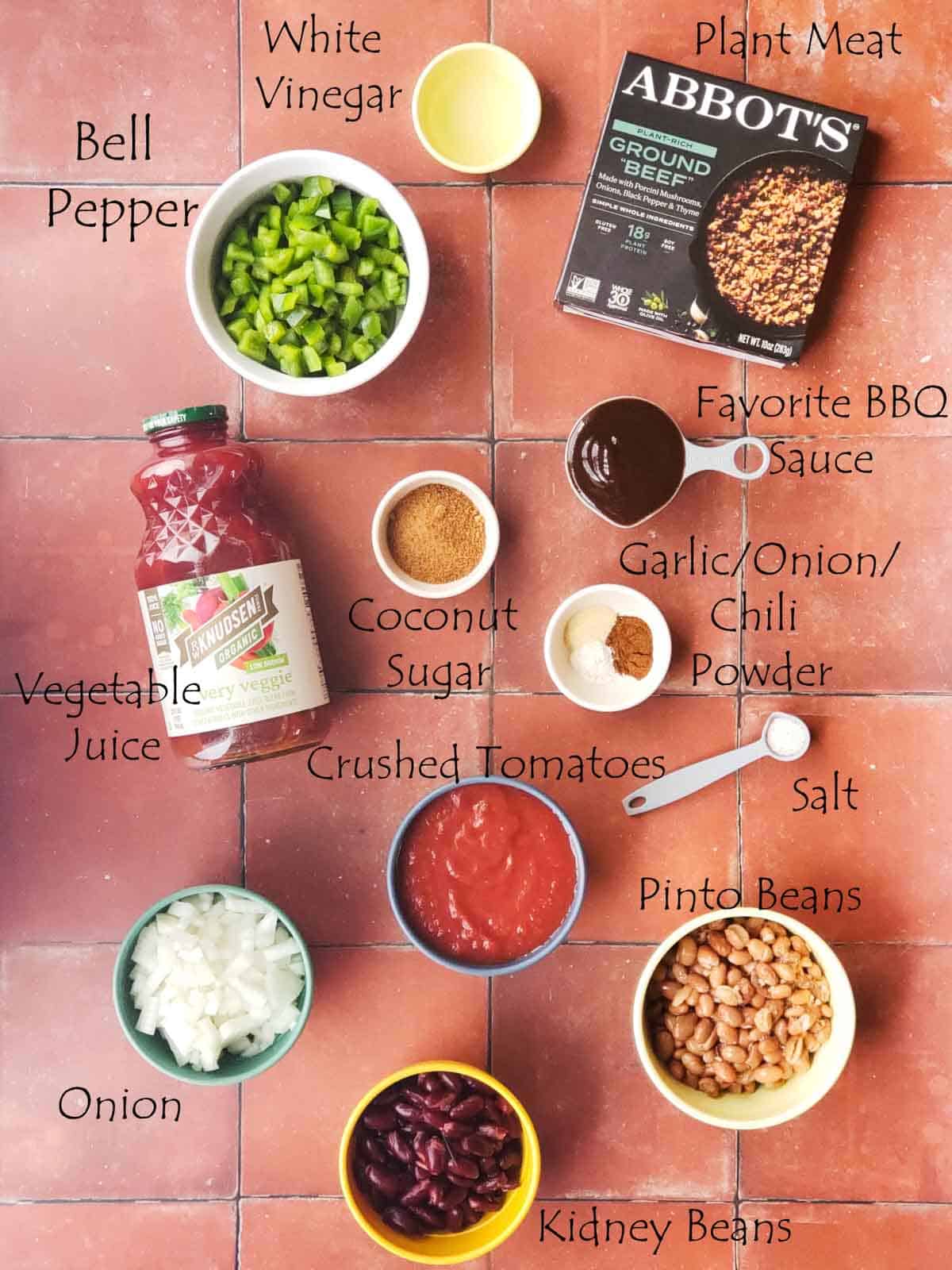 Overhead photo of vegan chili ingredients including beans, peppers, tomatoes, and plant-based ground.