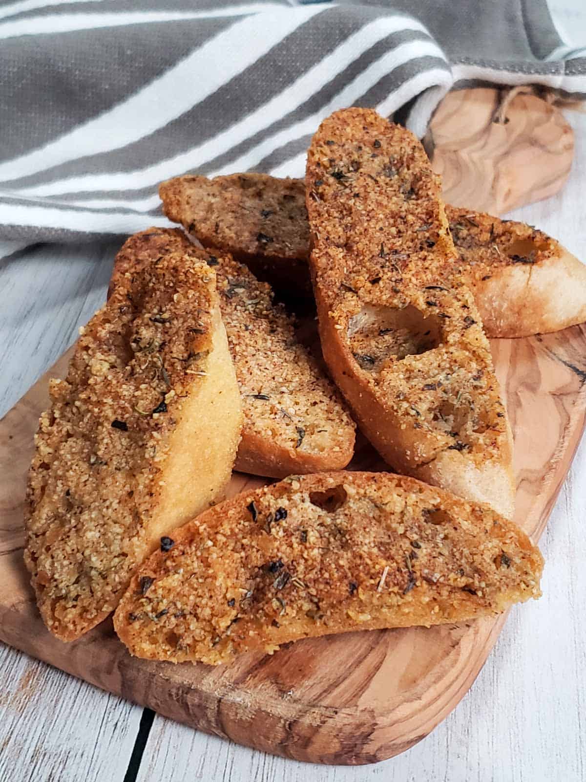 Homemade vegan garlic toast served on a wooden board, crispy and golden brown.