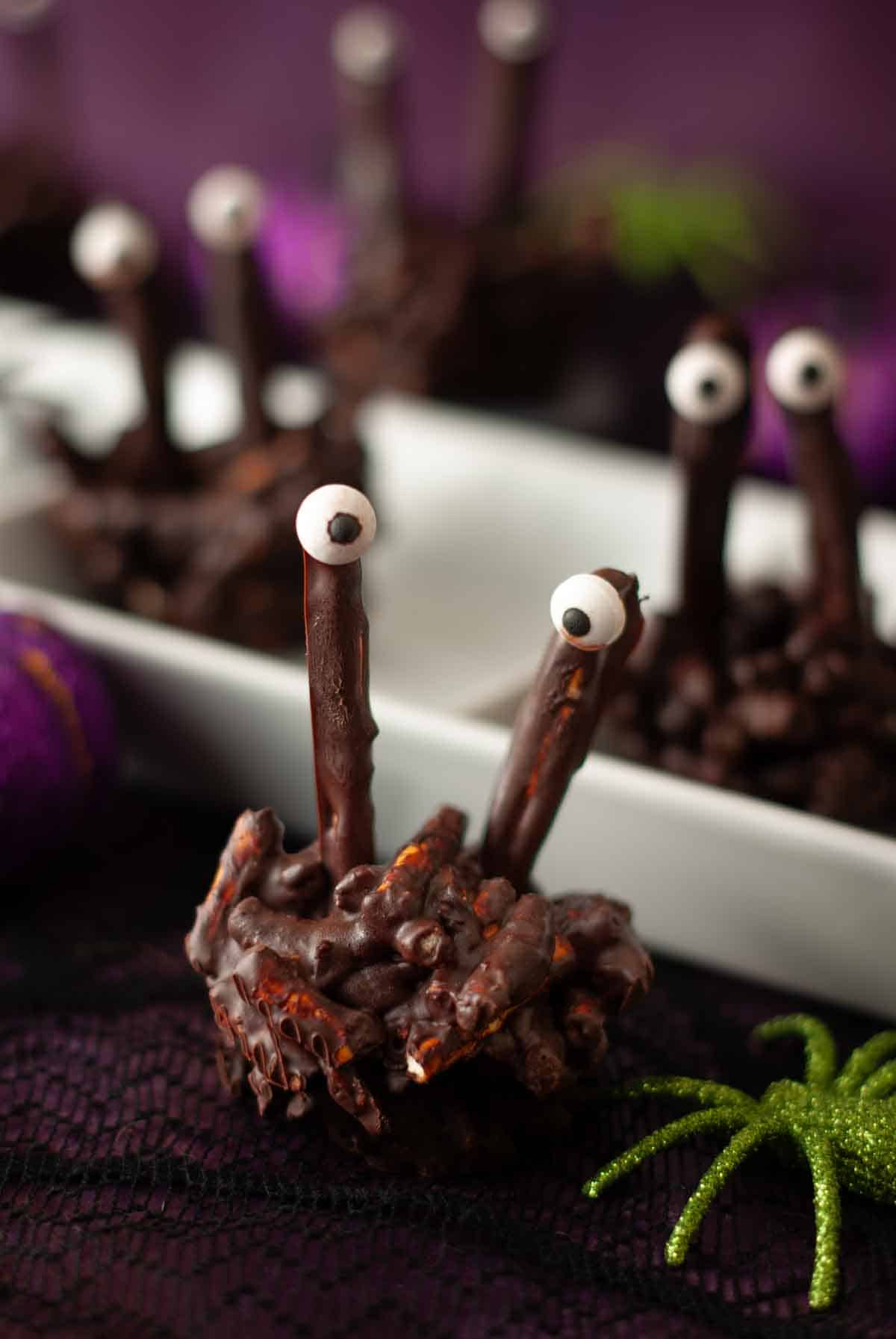Close-up of monsters with candy eyes on a purple Halloween table setting.