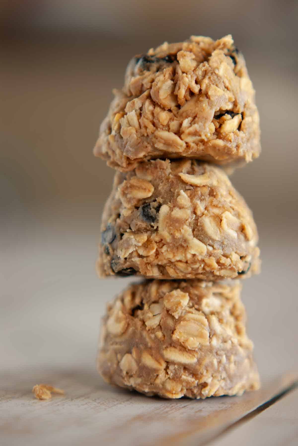 Close-up of three no-bake Sunbutter Energy Balls stacked on top of each other showing oats and dried blueberries.