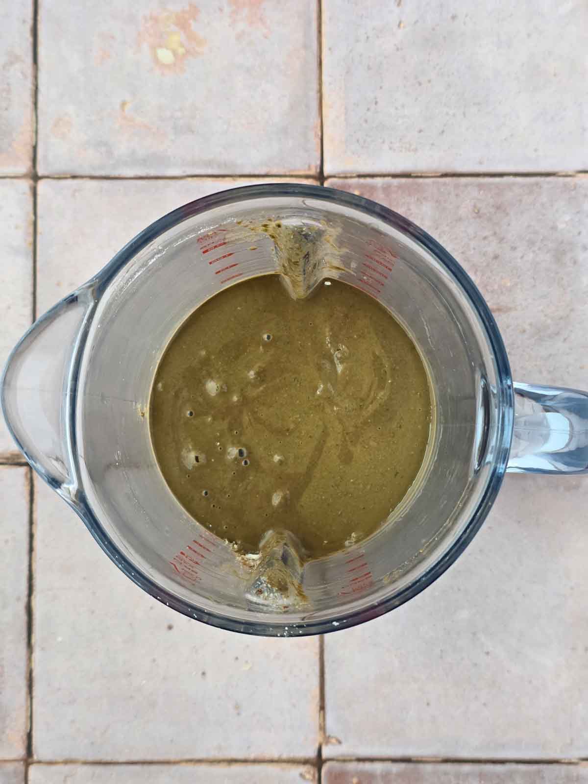 Blended chocolate waffle batter with kale fully mixed in, ready for oat flour to be stirred in.