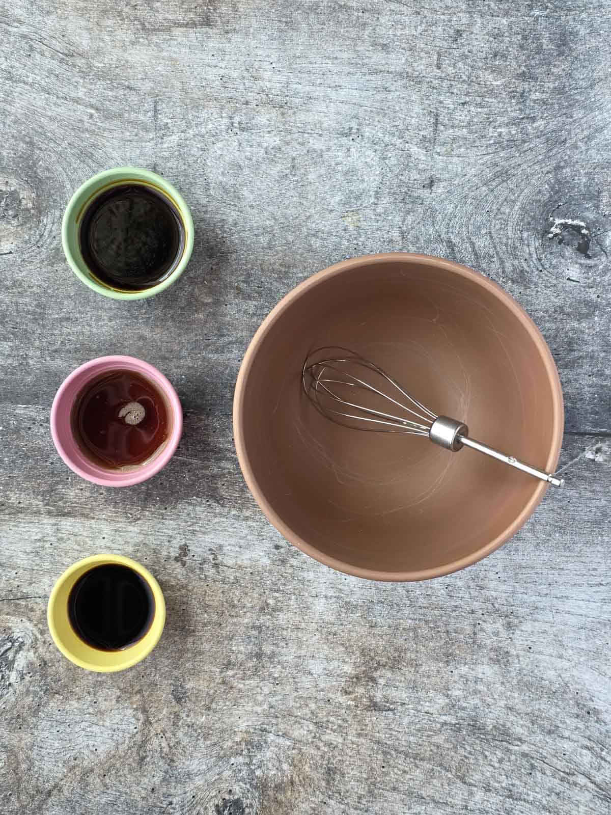 Measured sauces and seasonings arranged beside a mixing bowl and whisk.