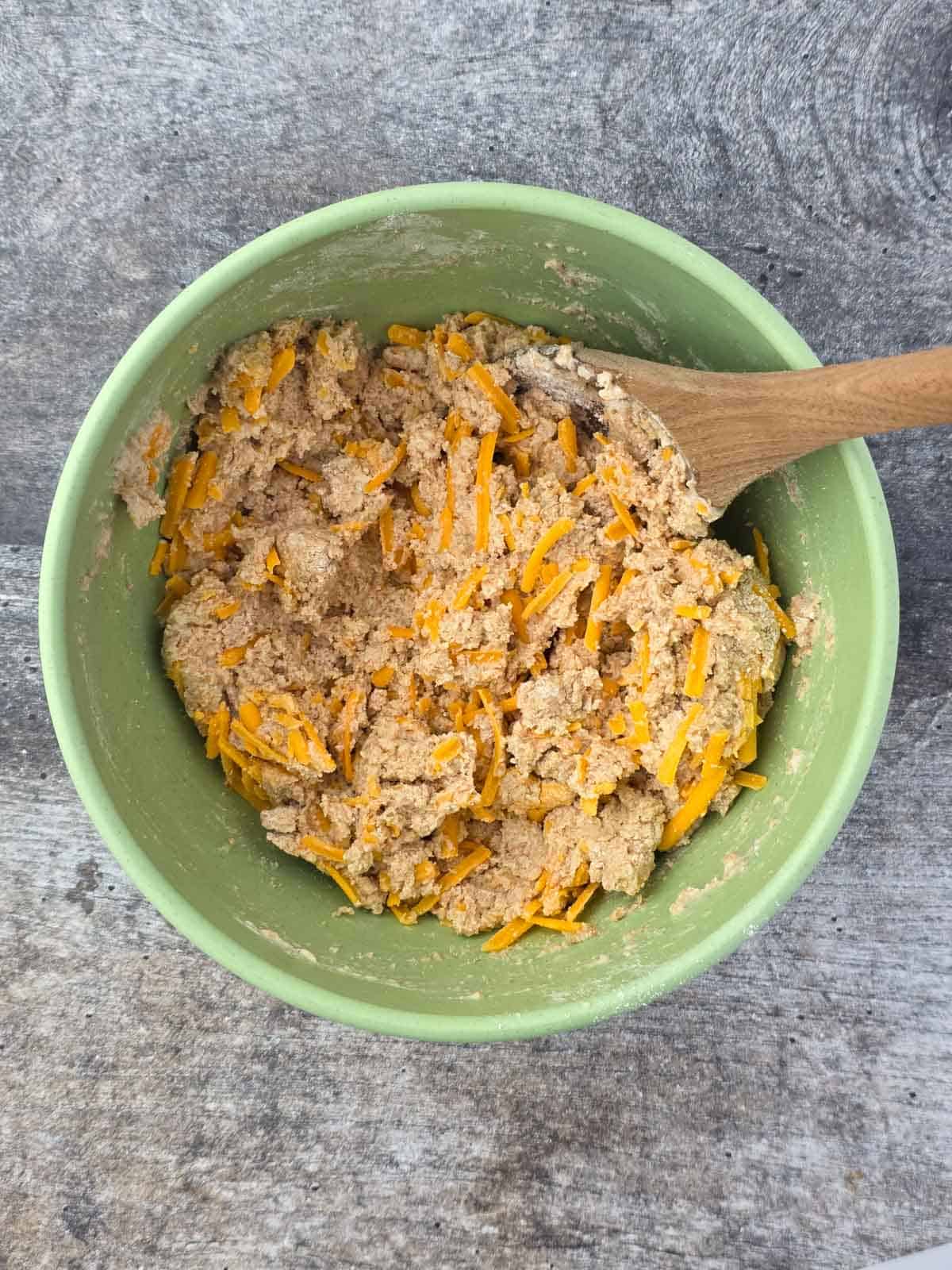 Bowl of mixed dough with vegan cheese evenly incorporated.