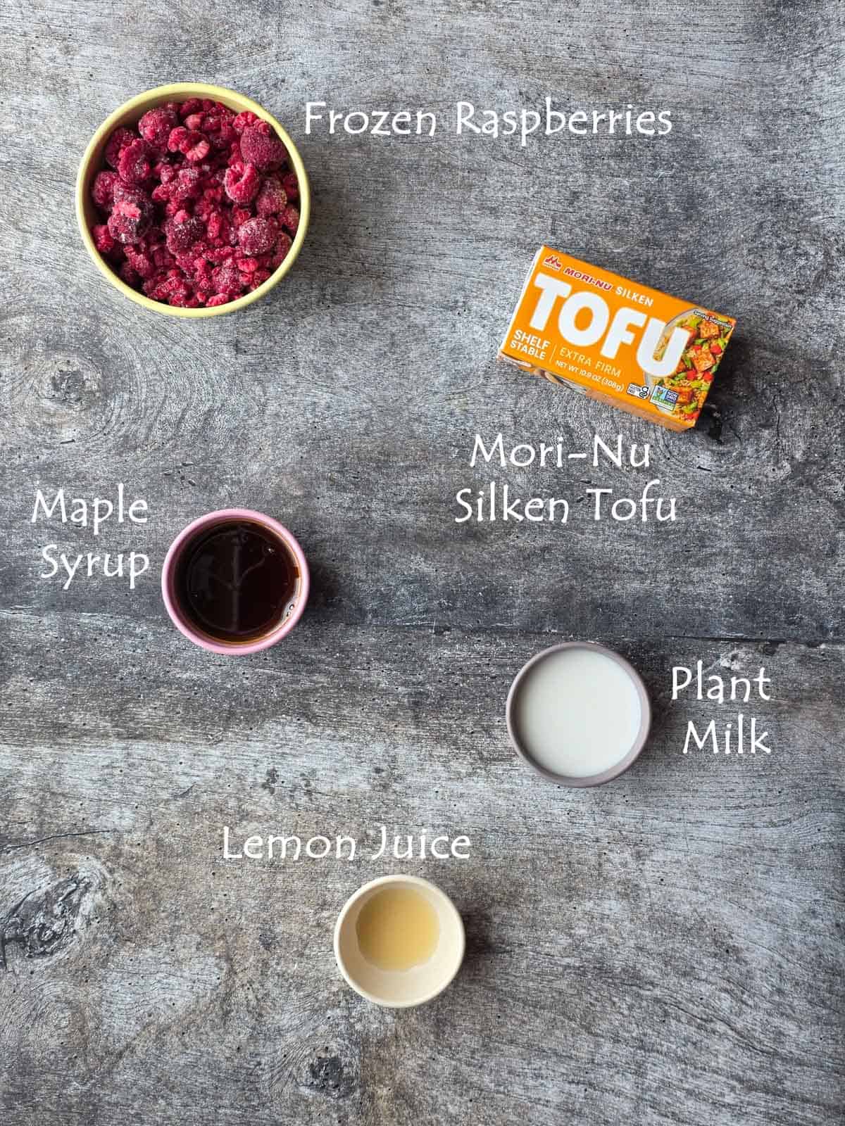 Flat lay of ingredients for Raspberry Pudding including tofu, syrup and plant milk.