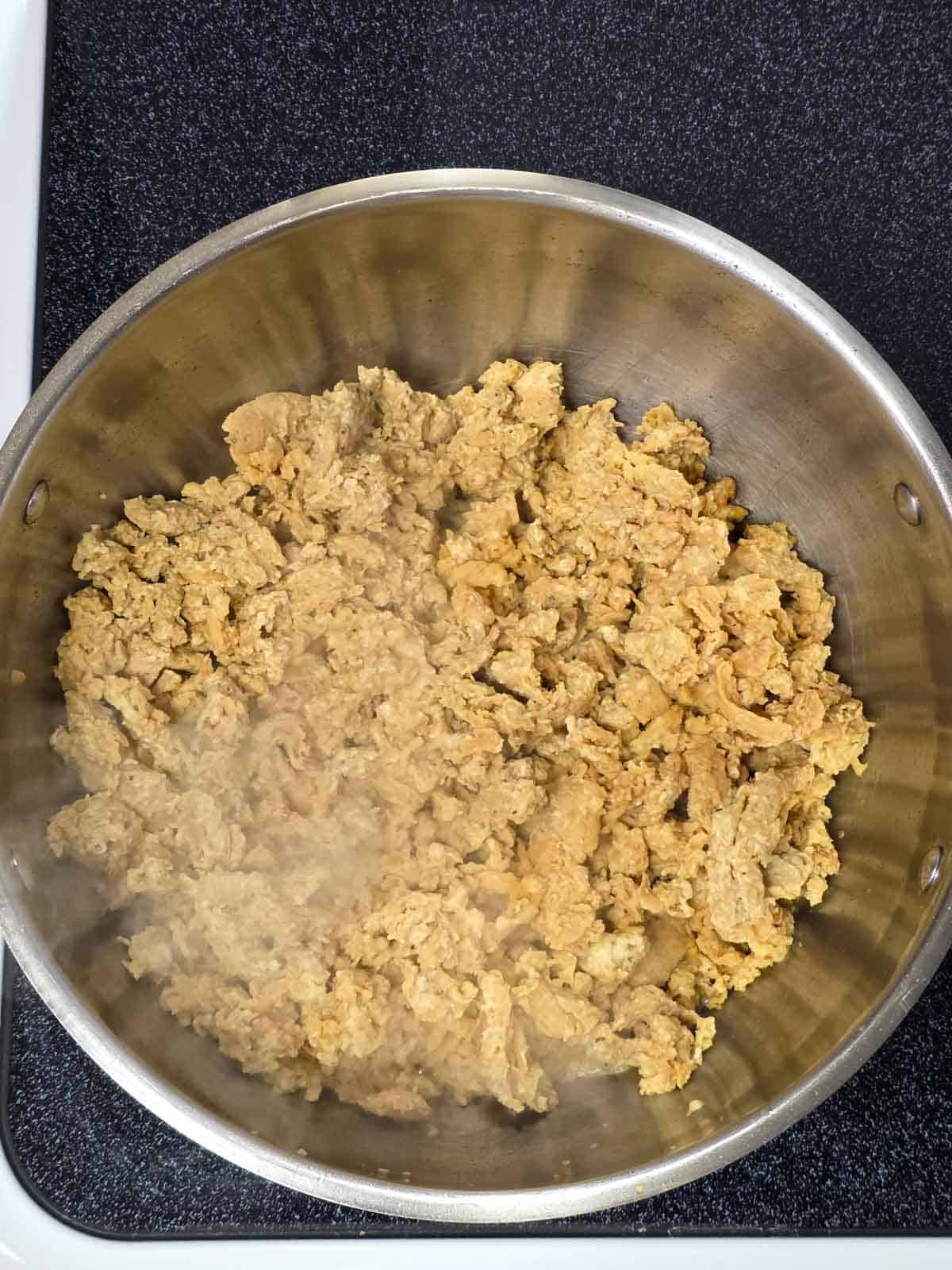 Soy curls cooking in the skillet, beginning to dry out and take on color.