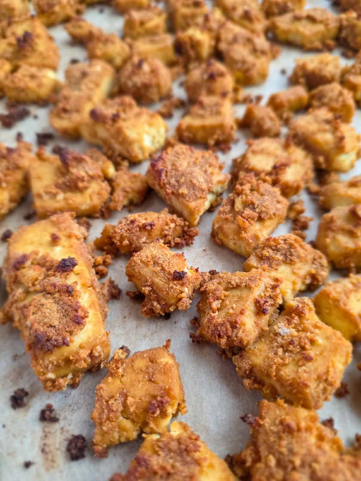 Close-up of crispy baked tofu nuggets showing crunchy edges and golden color.
