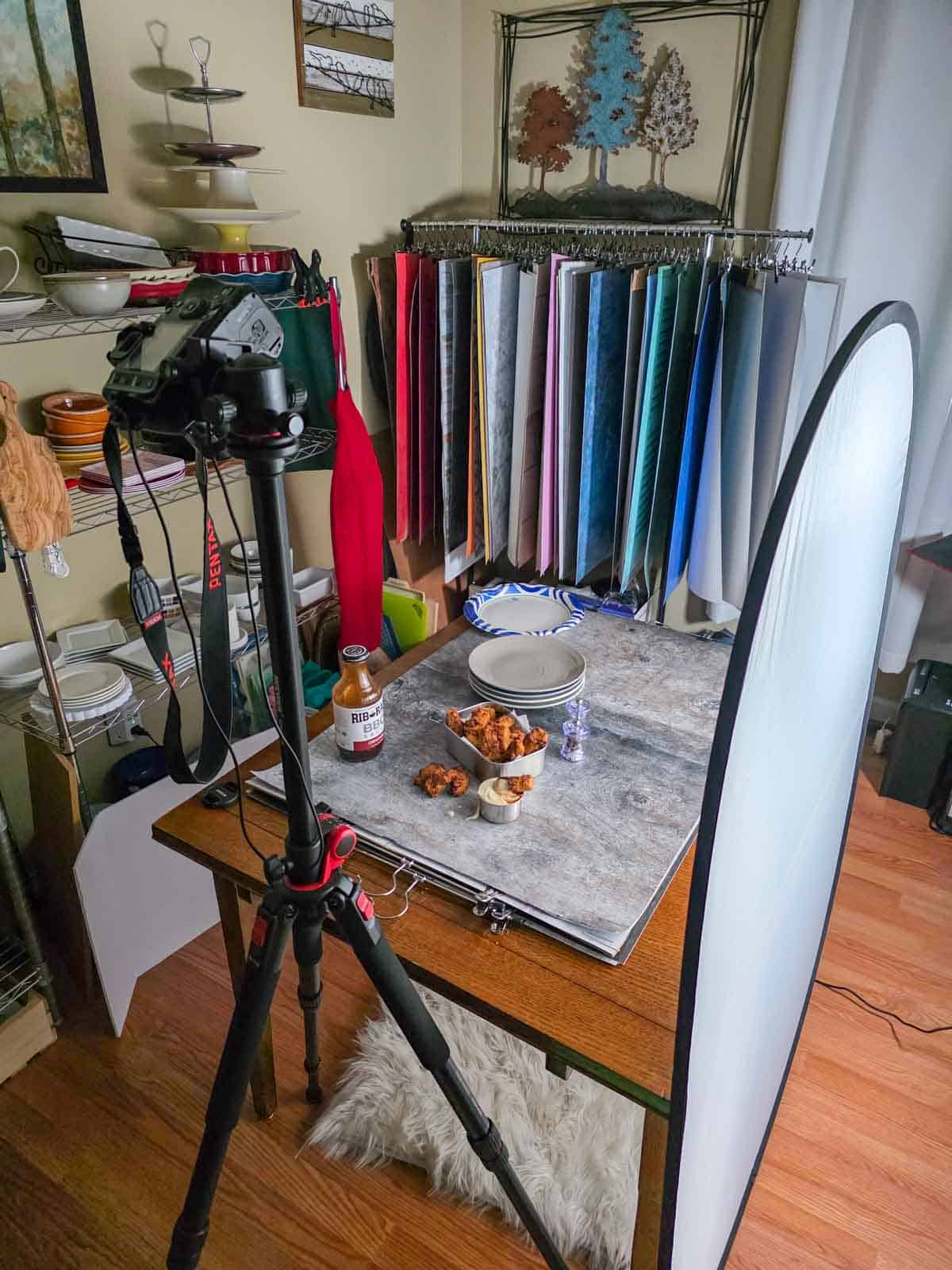 Behind-the-scenes food photography setup with camera, lighting, and main dish styled on a tabletop with bbq and ranch dipping sauce.
