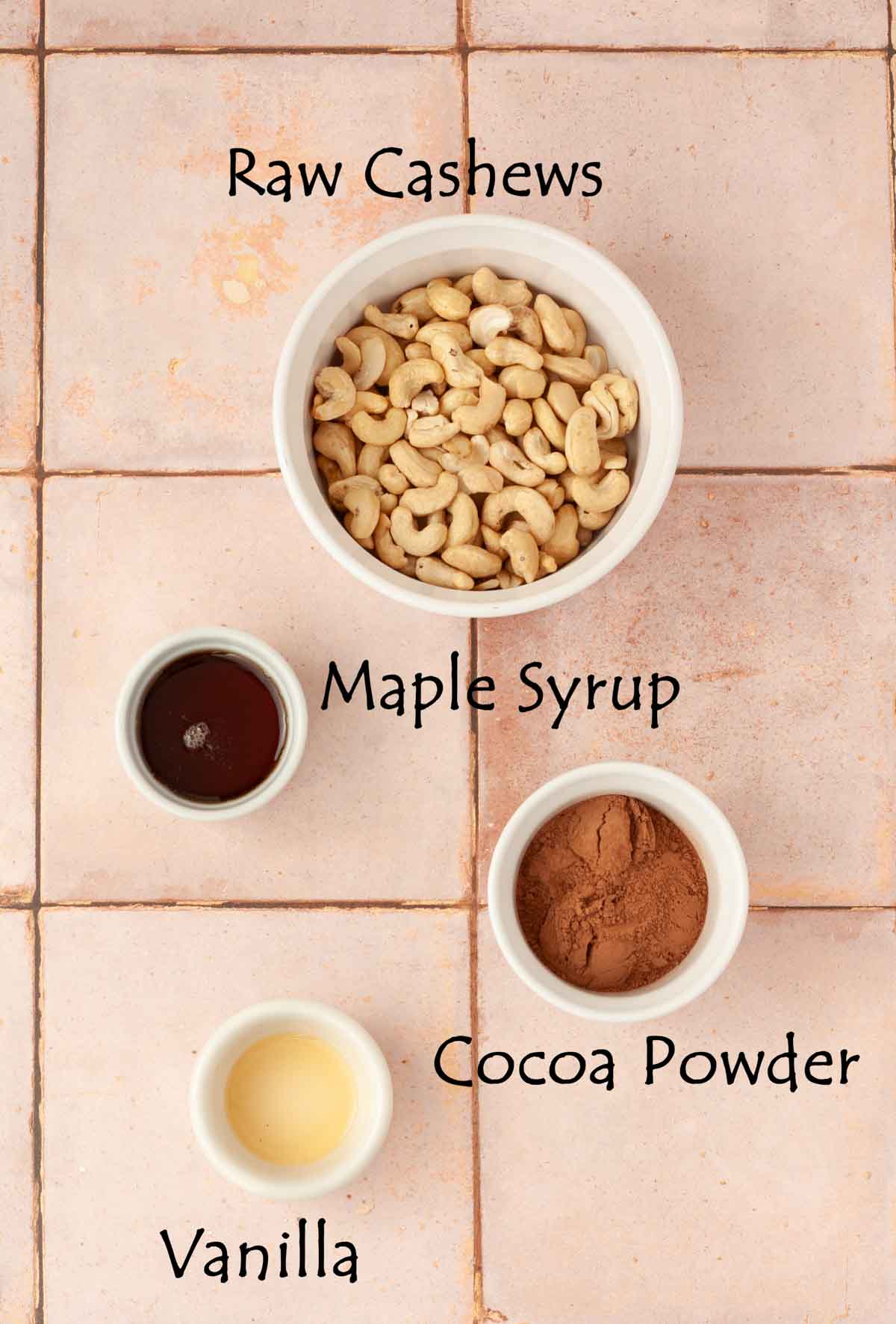 flatlay of ingredients in small bowls for making vegan chocolate milk including cashews and cocoa powder.