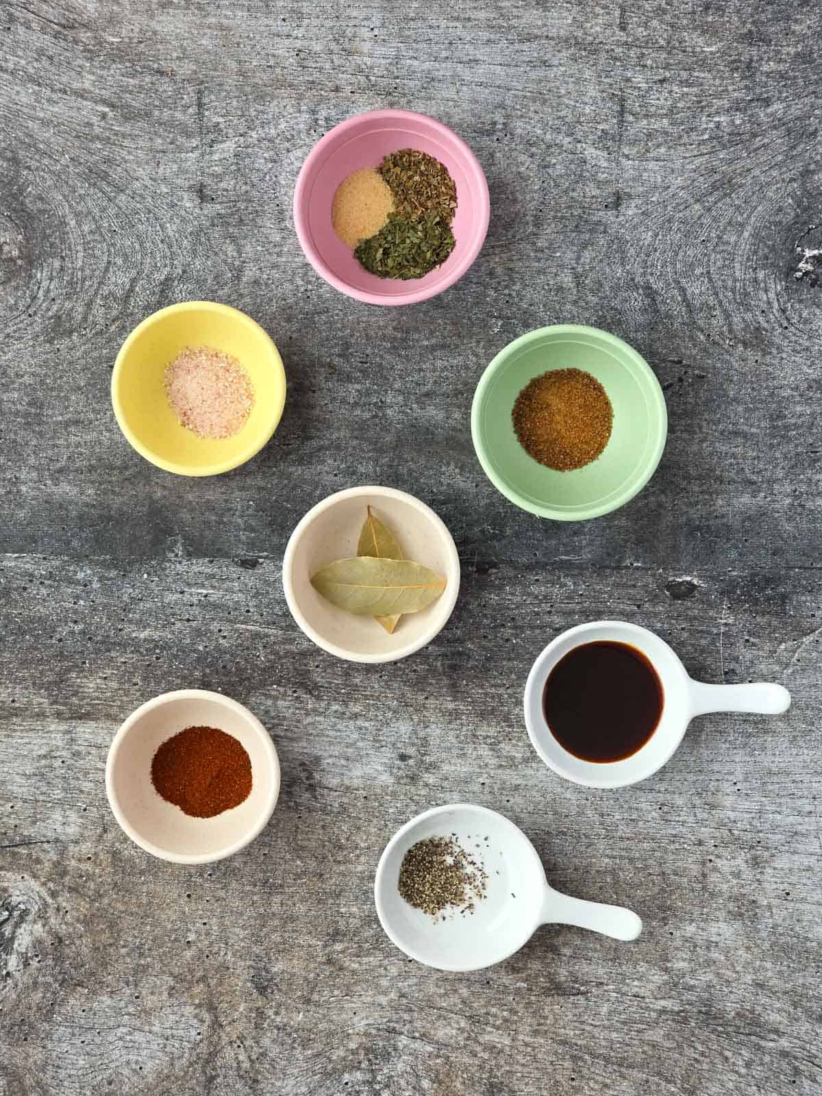 Measured seasonings including dried herbs, spices, bay leaves, and vegan Worcestershire sauce.