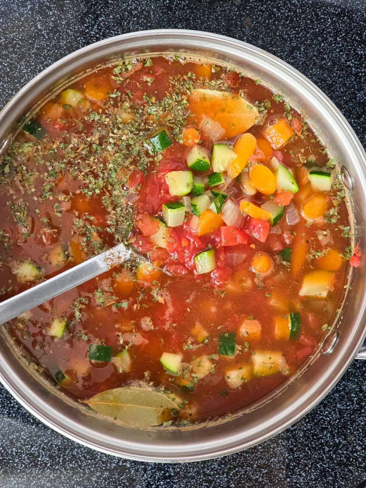 Vegetable barley soup stirred together after adding tomatoes, broth, and seasonings.
