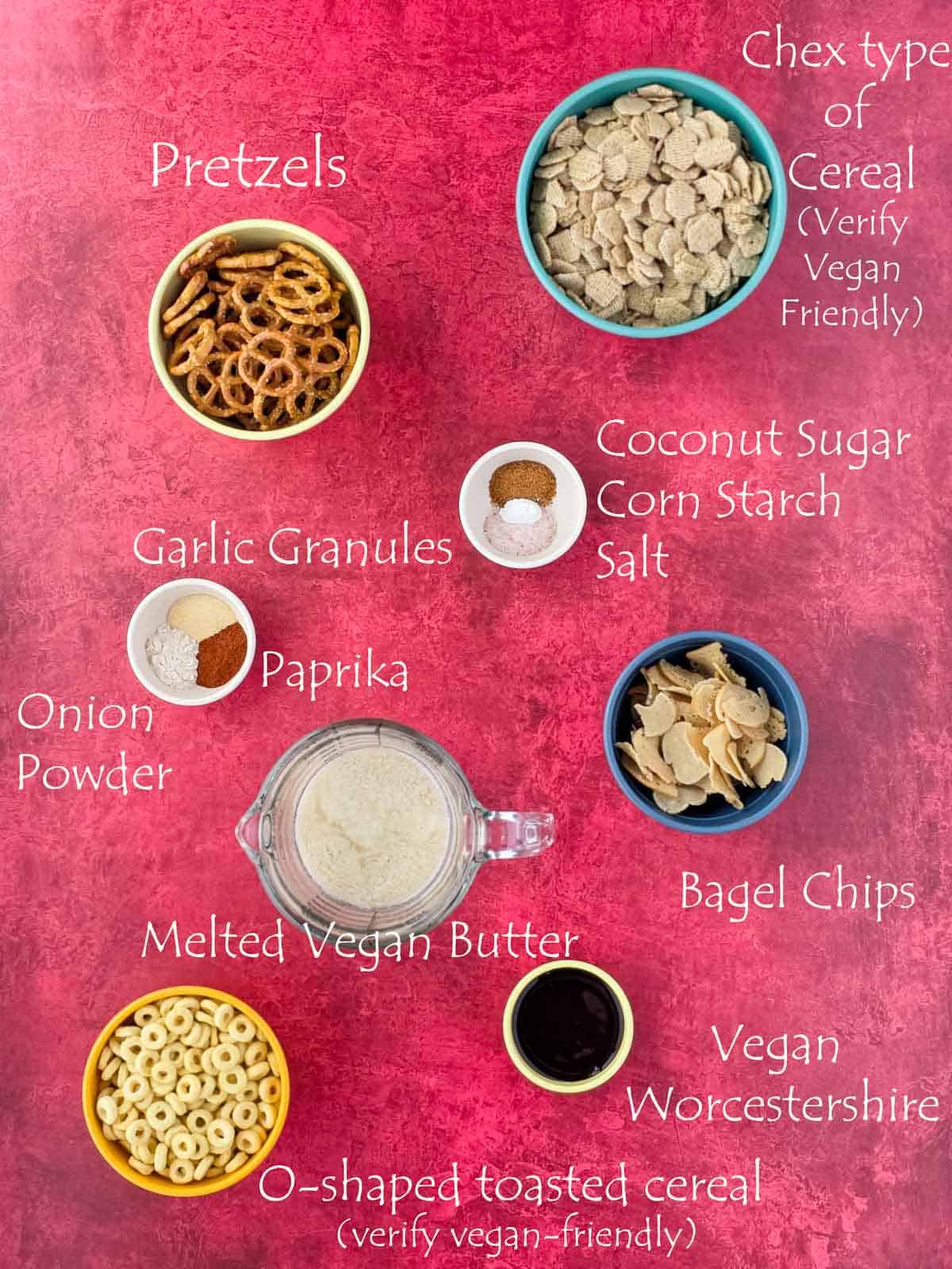 Flatlay of labeled ingredients including cereal, bagel crisps, and spices on a red backdrop.