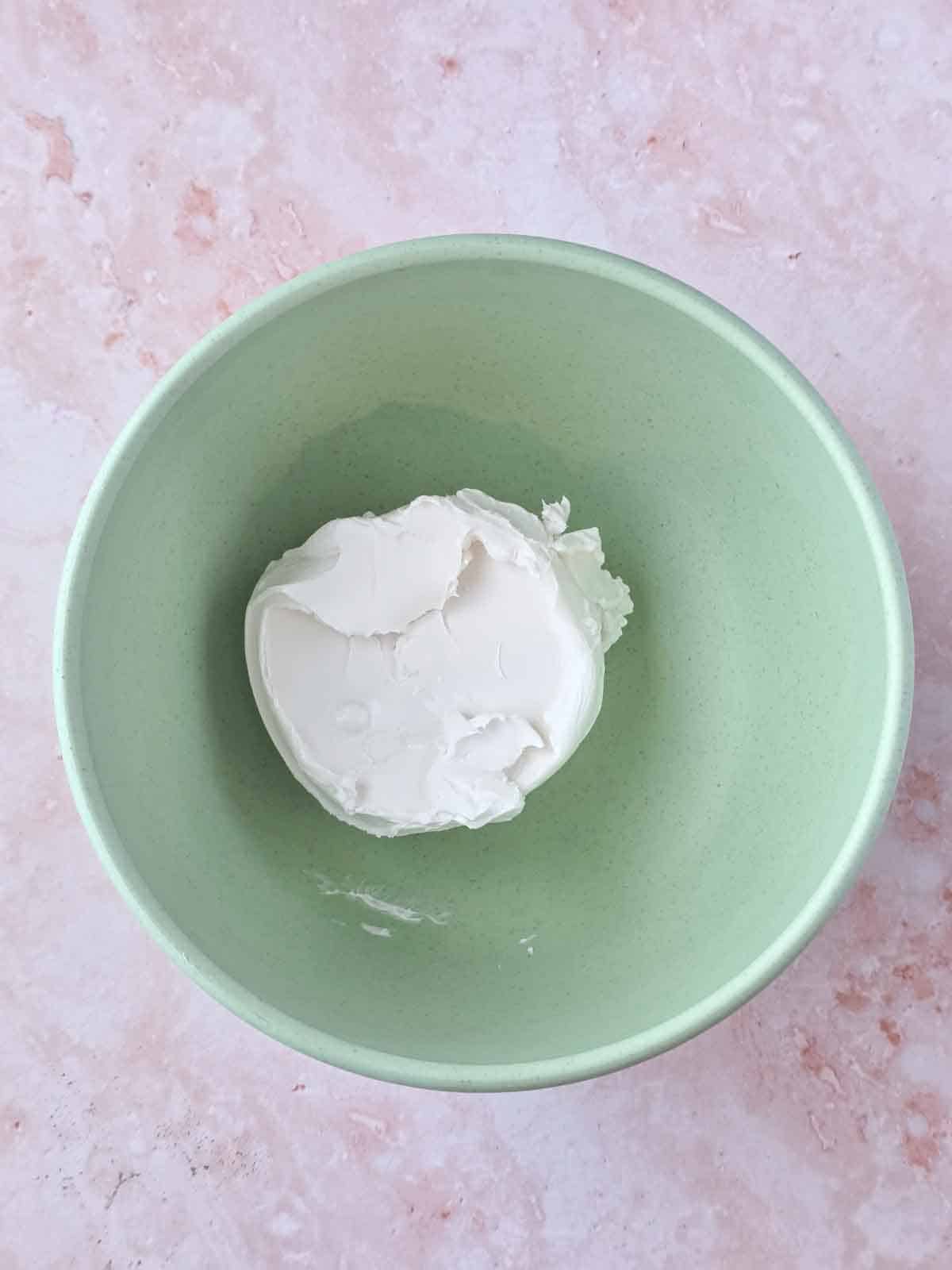 Plant based cream cheese in a mixing bowl for vegan cream cheese frosting.