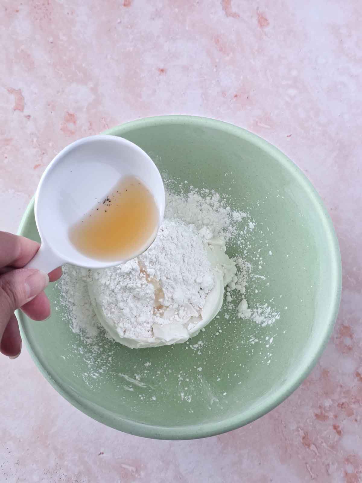 Adding vanilla extract to the bowl.