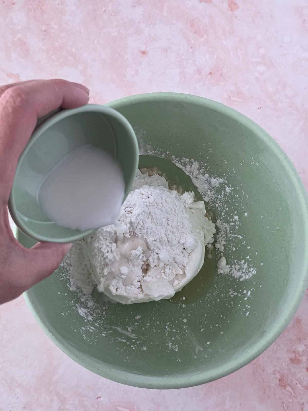 Adding plant milk to the bowl.