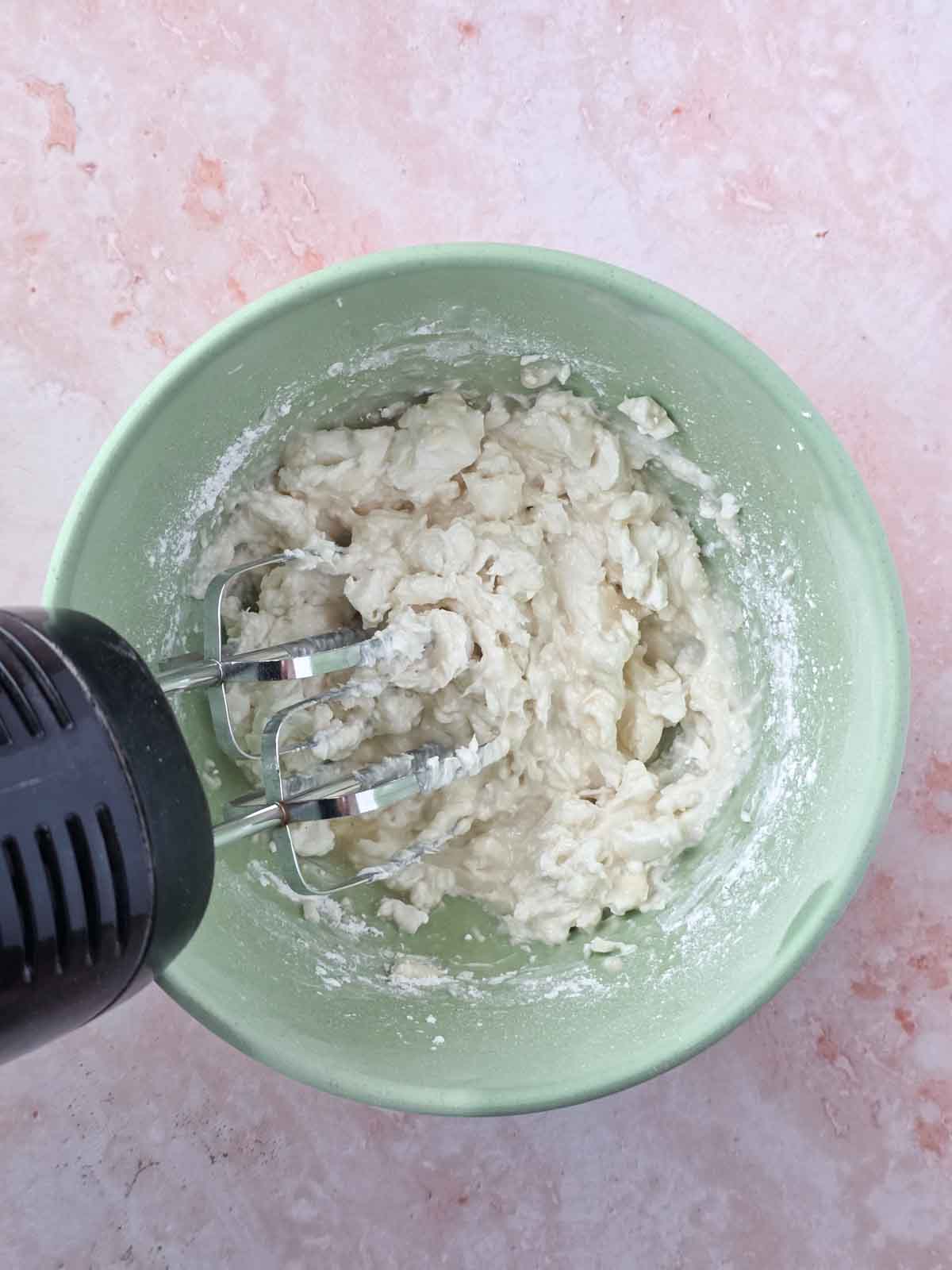 Mixing ingredients with a hand mixer.
