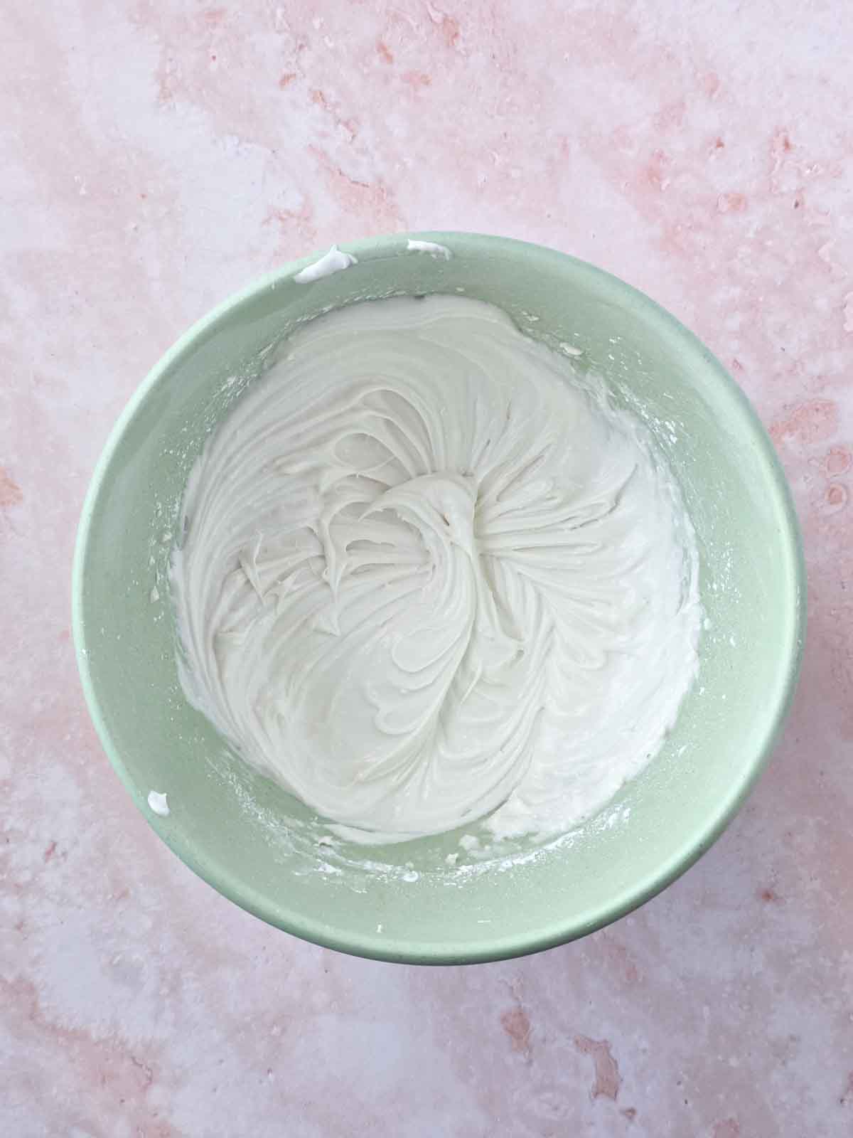 Smooth and creamy vegan cream cheese frosting in mixing bowl.