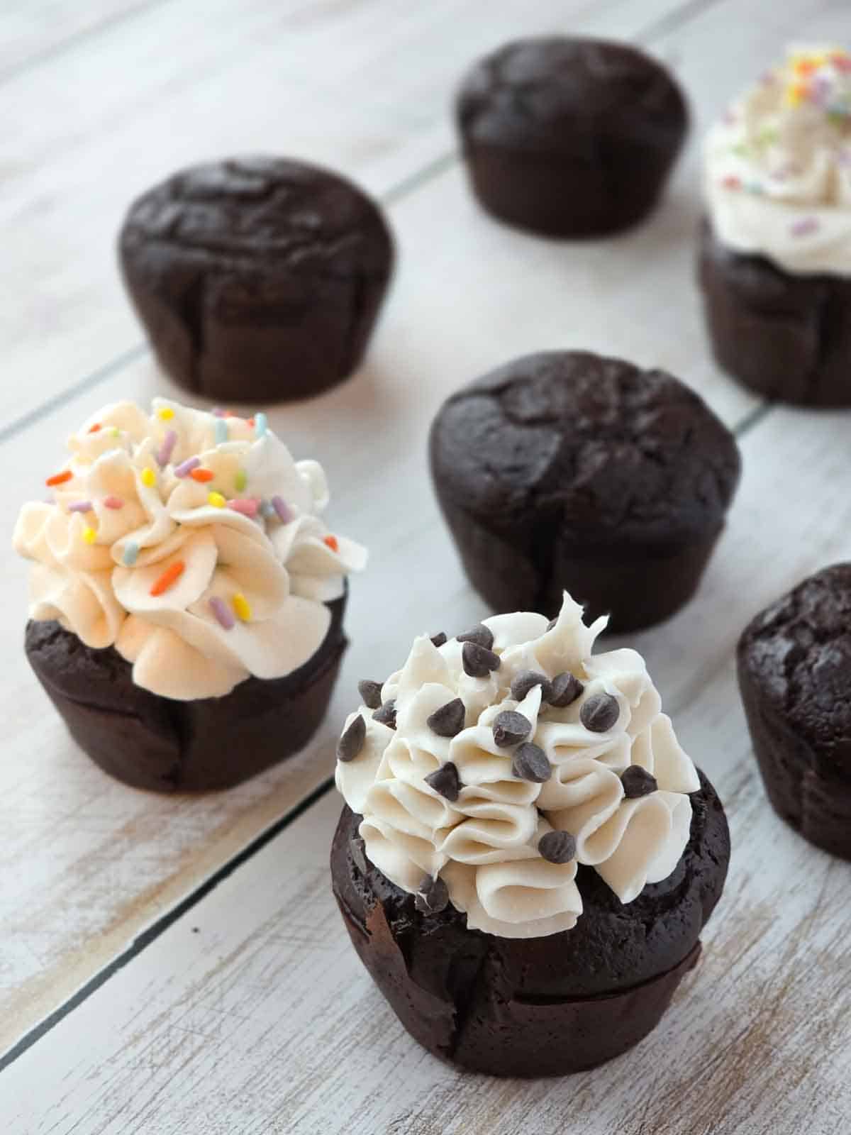 Vegan chocolate cupcakes with cream cheese frosting and sprinkles.