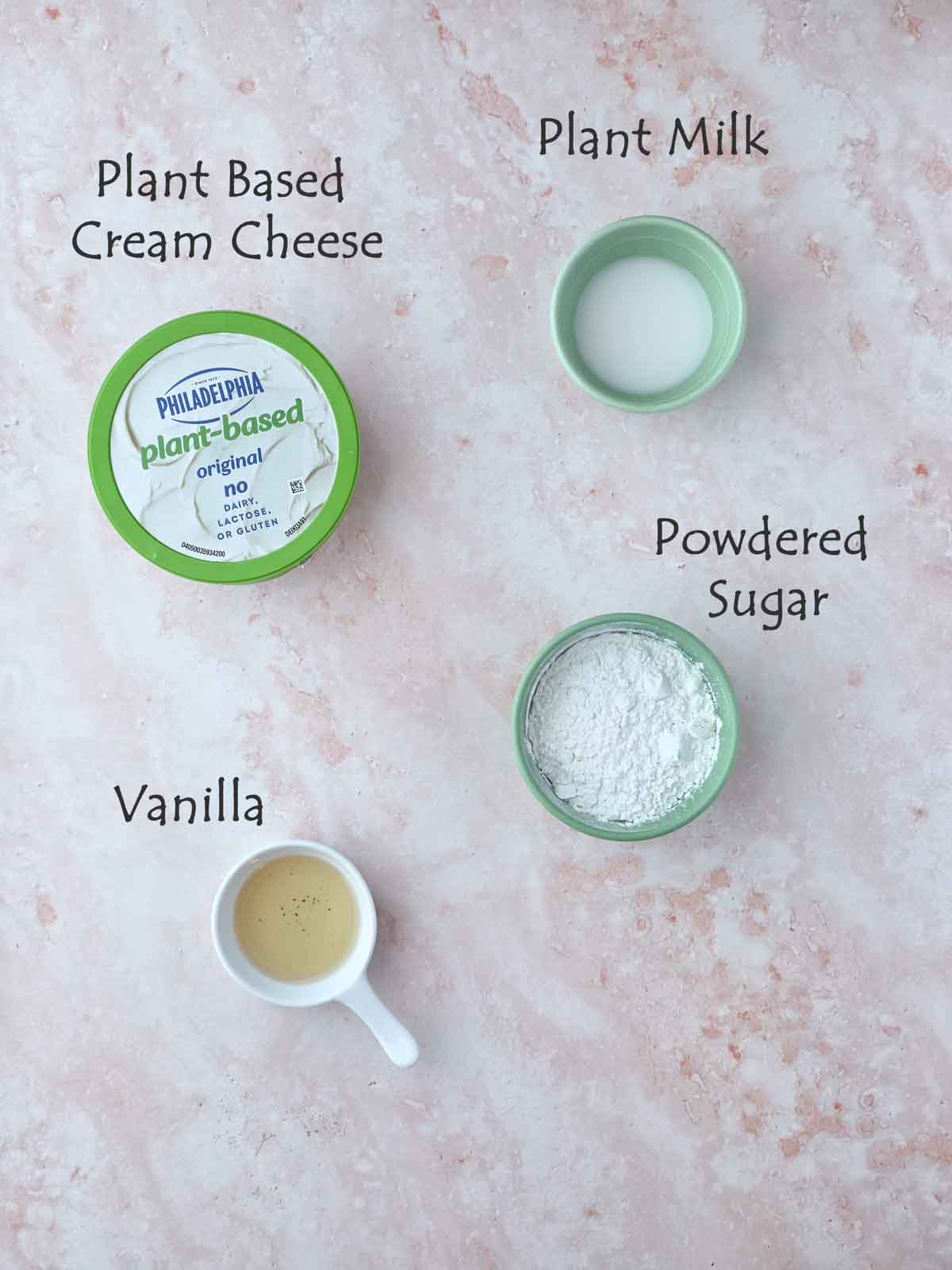 Labeled ingredients for including plant based cream cheese, powdered sugar, vanilla, and plant milk.