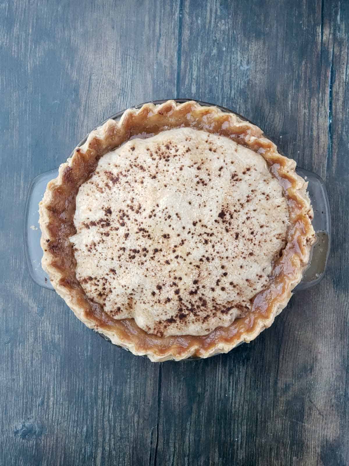 Freshly baked apple pie on a wooden table.