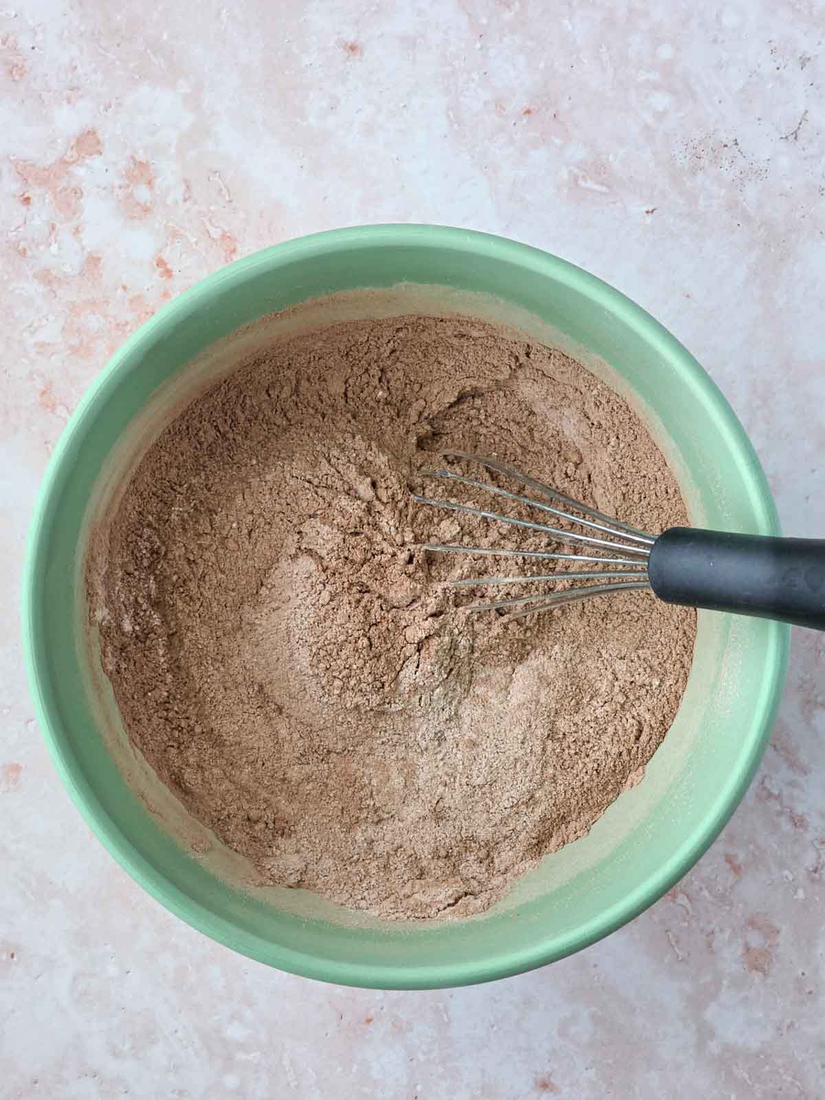 Dry chocolate cupcake ingredients whisked together in a mixing bowl.