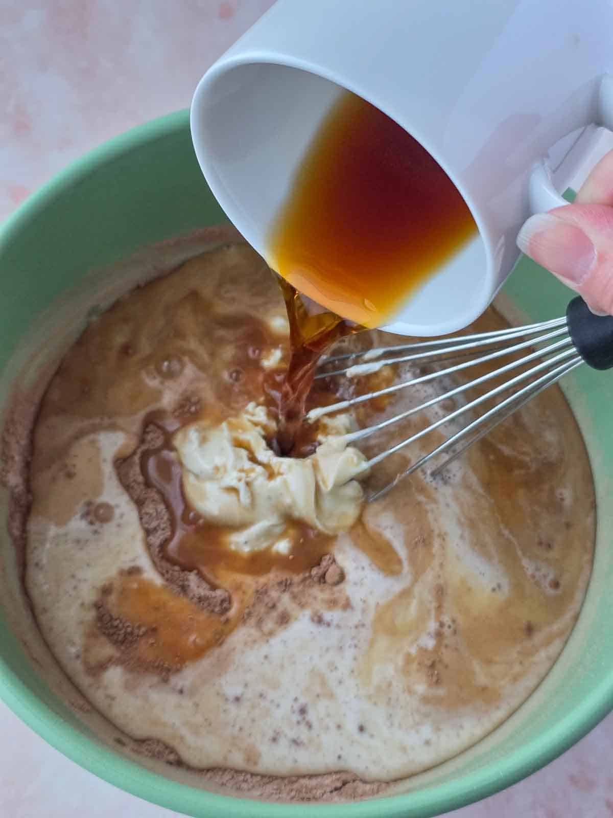 Strong brewed coffee being added to the cupcake batter mixture.