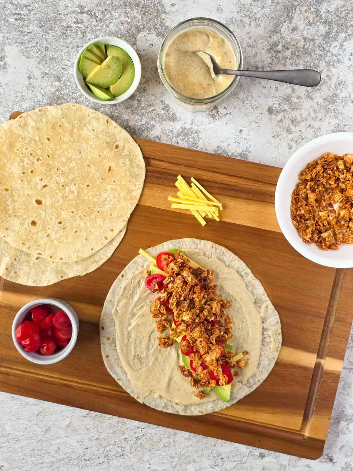 Crispy coconut bacon sprinkled over fresh toppings on a tortilla wrap.