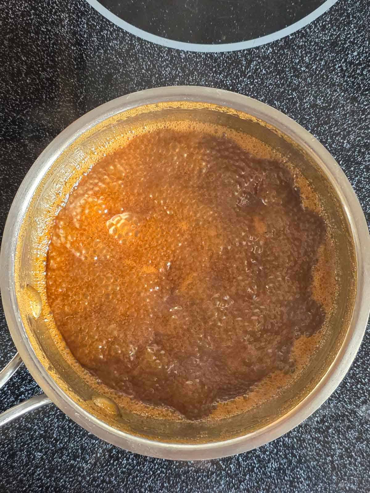 Caramel sauce simmering in a pan.