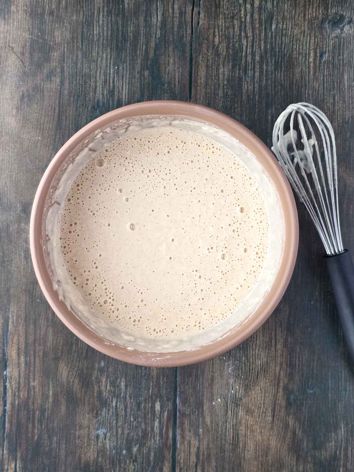 Pancake batter after resting with bubbles forming on the surface.