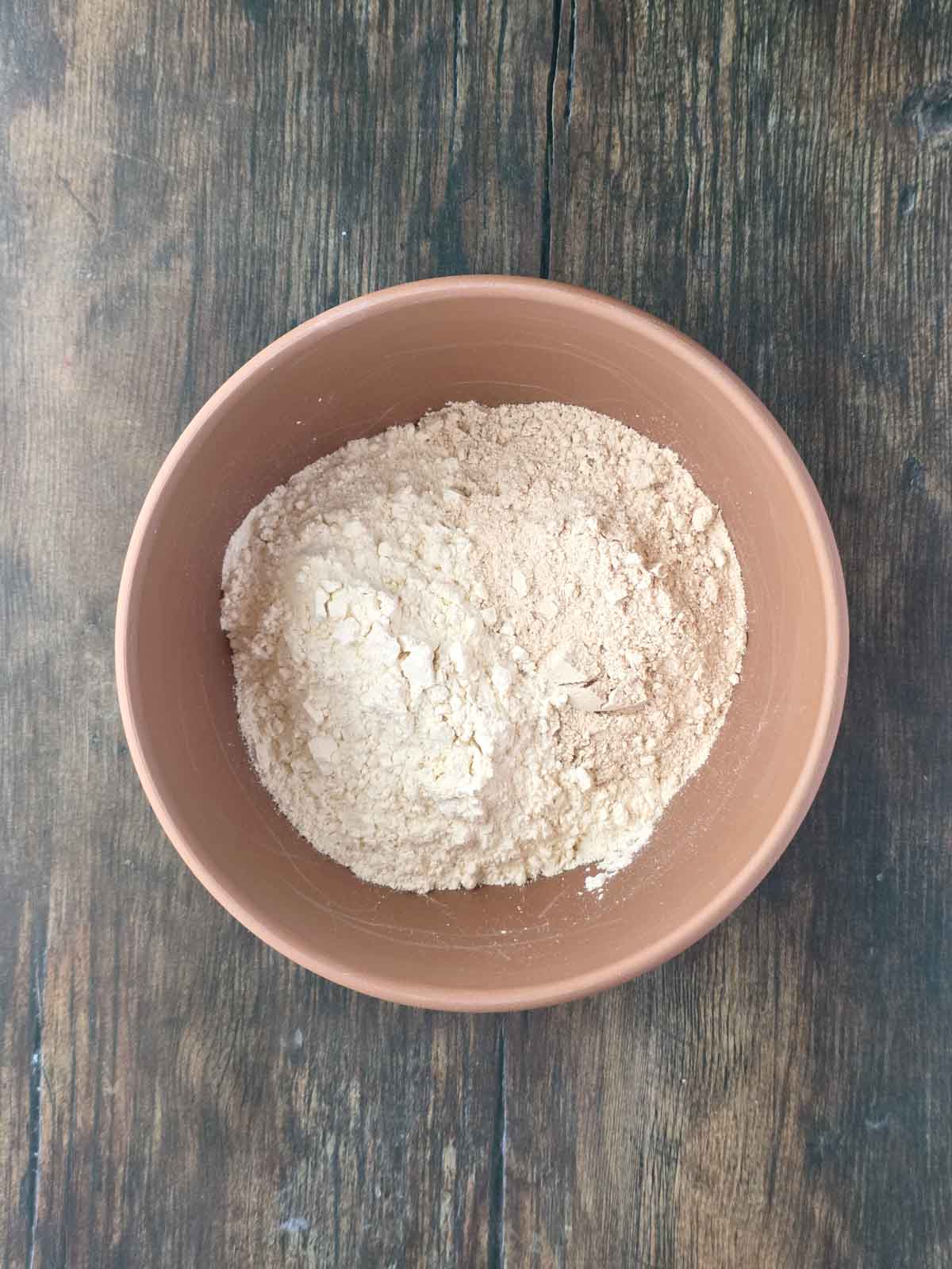 Bowl with all-purpose flour and whole wheat flour for homemade pancakes.