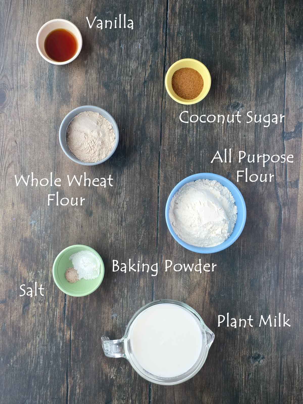 Overhead view of thick and fluffy pancake ingredients including flour, plant milk, vanilla, and coconut sugar.