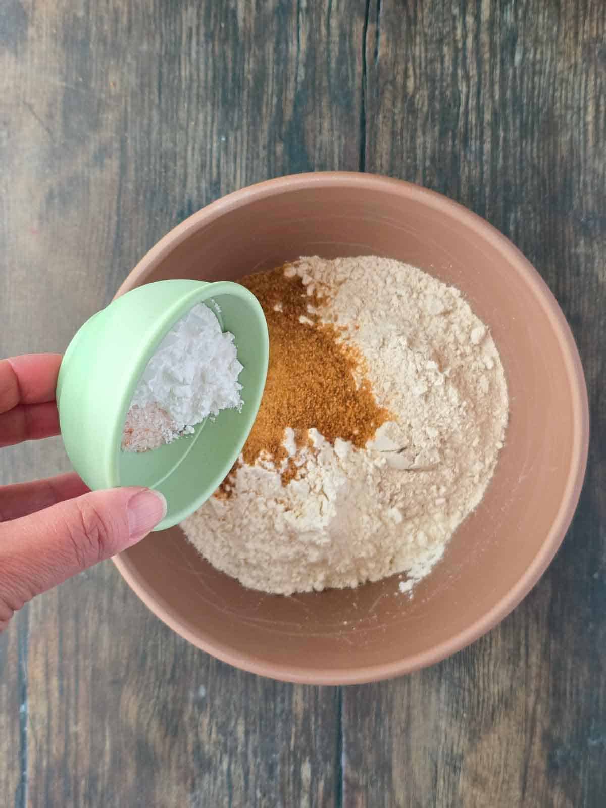 Adding baking powder and salt to the flour mixture.