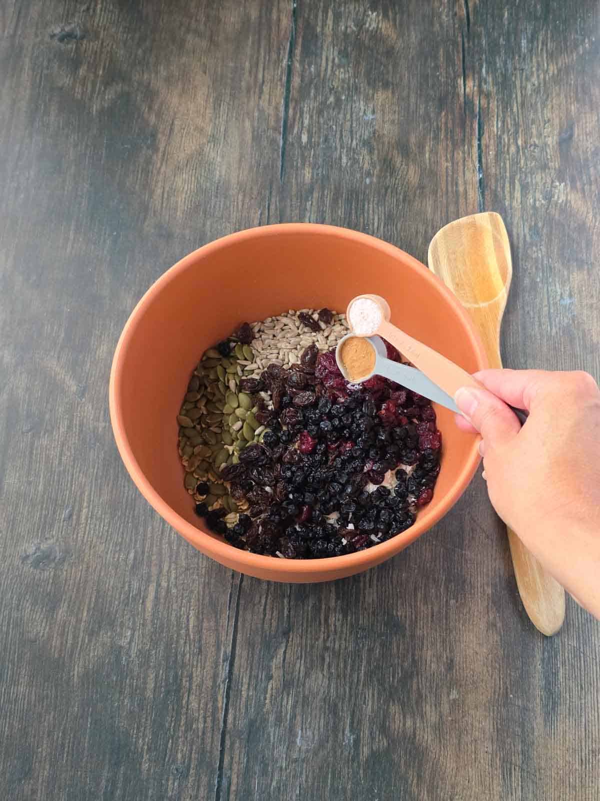 Adding cinnamon and salt to the granola bar ingredients.