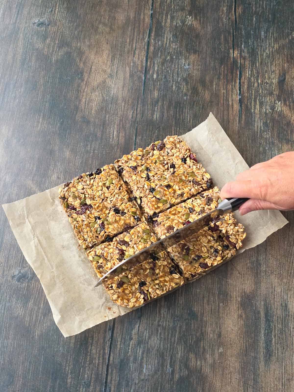 Cutting the chilled triple berry granola mixture into individual bars.